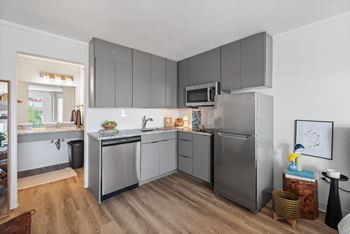 A modern kitchen with a refrigerator, microwave, and oven.